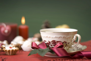 hot cup of tea with ribbon, cookies and candle