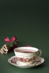 cup of tea on green background with sticks