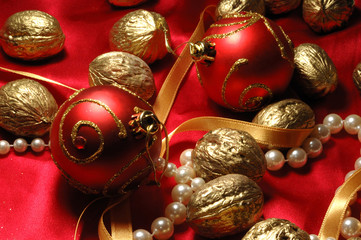 Red christmas balls and golden walnuts on red silk