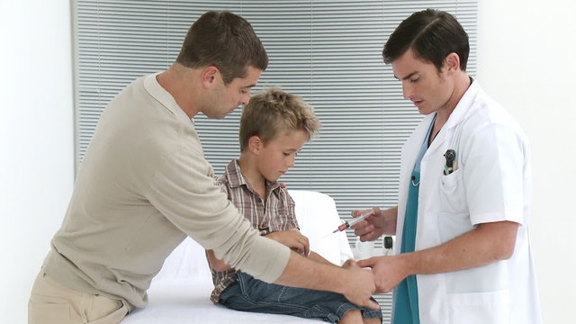 Doctor giving a little boy an injection