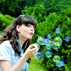 Young girl blowing soap bubbles