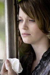 Frau schaut traurig aus dem Fenster