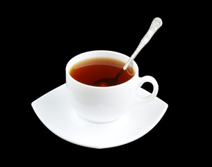 Cup of fresh tea with spoon and saucer isolated on black