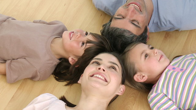 Family lying on floor with heads together at home