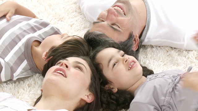 Family lying on floor with heads together