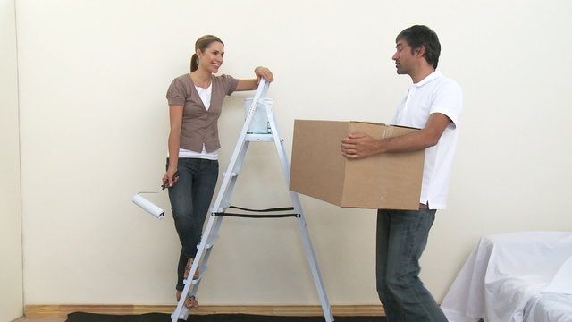 Couple painting a room in new house