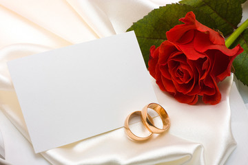 Wedding rings, rose and card
