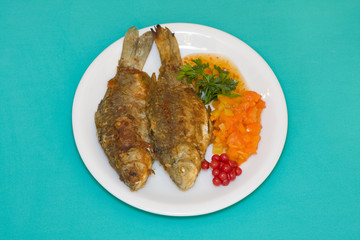 Fried fish in plate on a green background