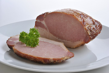 cooked organic back bacon joint on a plate