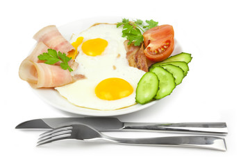 fried eggs with bacon and vegetables / on white background