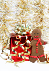 Gingerbread man cookie with a red scarf standing next to Christm