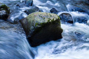 Bach mit fließendem Wasser und Steinen (Felsen)