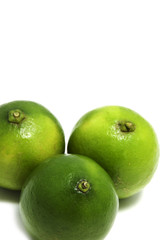 three green limes on a white background