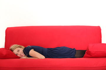 hübsche frau auf rotem sofa