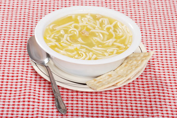 chicken noodle soup with spoon and crackers