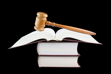 Judge's gavel and stack of legal books isolated on black