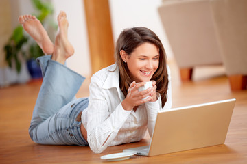 Woman with laptop and coffee on the floor