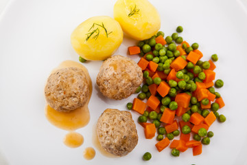 Roasted meatballs with boiled potatoes, peas and carrot