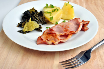 bacon, cabbage and organic potato on a plate