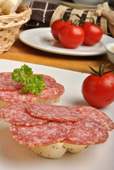 slice poppy seed bread with salami on a plate