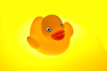 Gelbe Badeente auf gelb-leuchtendem Untergrund