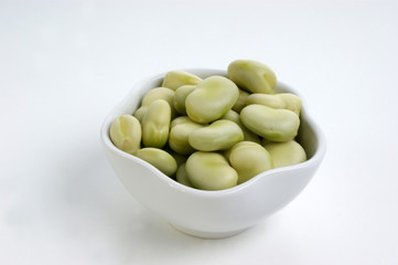 some organic broad beans in a white bowl
