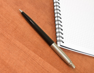 Pen with a white spiral squared notebook