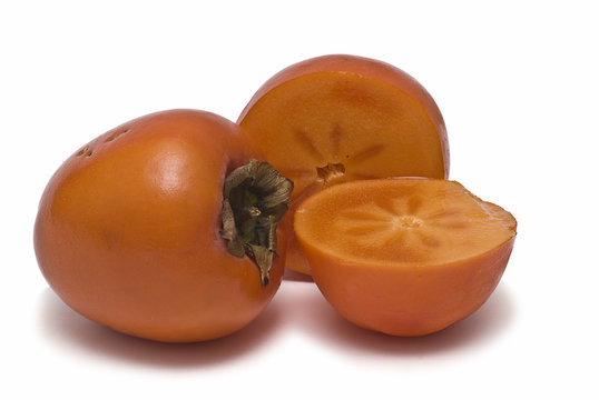 Kaki entero y cortado a la mitad.