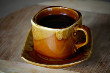 cup of black fragrant coffee on a wooden board