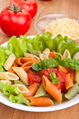 colored penne pasta with tomato sauce and basil