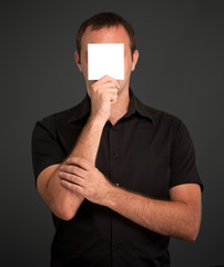 Man hiding behind a blank note