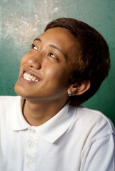 Happy smiling asian male teenager looking up