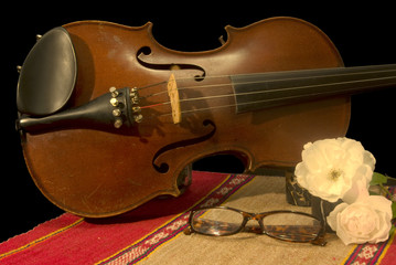 Vecchio violino con rose e occhiali