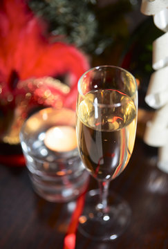 Sparkling wine and candle in blurred festive background