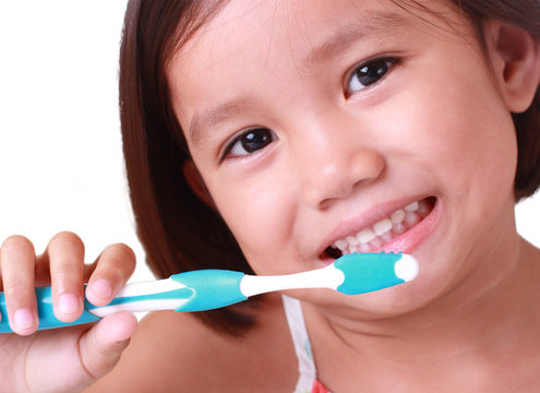 close up of little girl brushing her teeth
