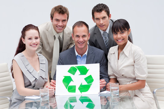 Smiling business team holding a recycling symbol. Ecological bus
