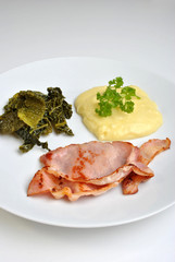 bacon, cabbage and mashed potato on a plate