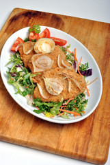 breaded fish steak with organic herbs on a plate