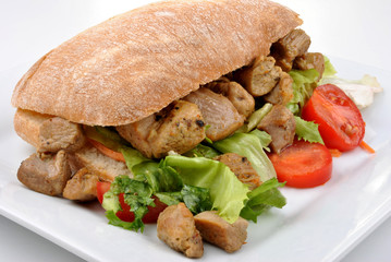 bread roll with organic salad, pork and tomato