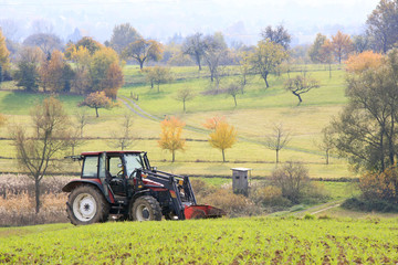 Fototapeta premium Traktor steht in der Landschaft