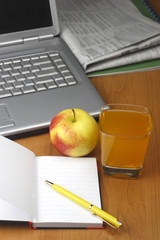 Orange juice,laptop,apple notepad and  pen