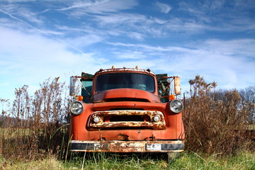 Old Dented Pickup in Field with Blue Sky