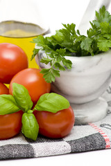 tomatoes, basil, parsley and bottle of olive oil