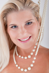 young woman with healthy white teeth and pearls