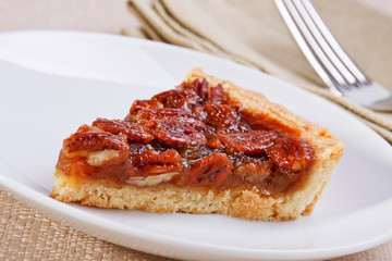 Fresh slice of sweet and tasty pecan pie - high key