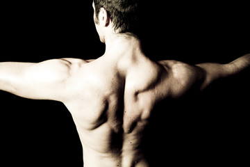 Fototapeta na wymiar man with big muscular back on black background