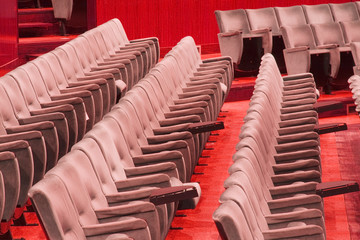 Fototapeta premium Empty chairs at cinema or theater, red tone