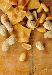 Peanut Brittle with Peanuts on Wood Table
