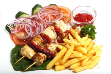 Chiken shish kebab with fried potatoes and vegetables