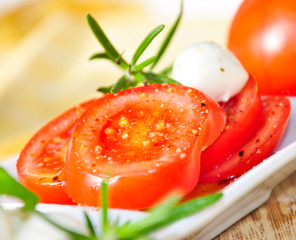Gewürzte Tomatenscheiben mit Mozzarella und Rosmarin